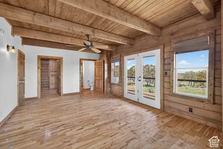 Wood-planked flooring with exposed wood beam ceiling and wood-paneled walls