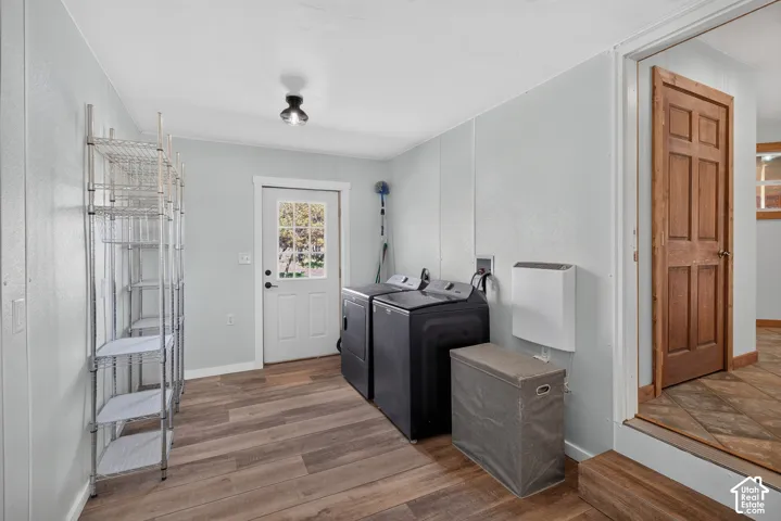 Wood-finish flooring, paneled walls, and a white exterior door with glass panes