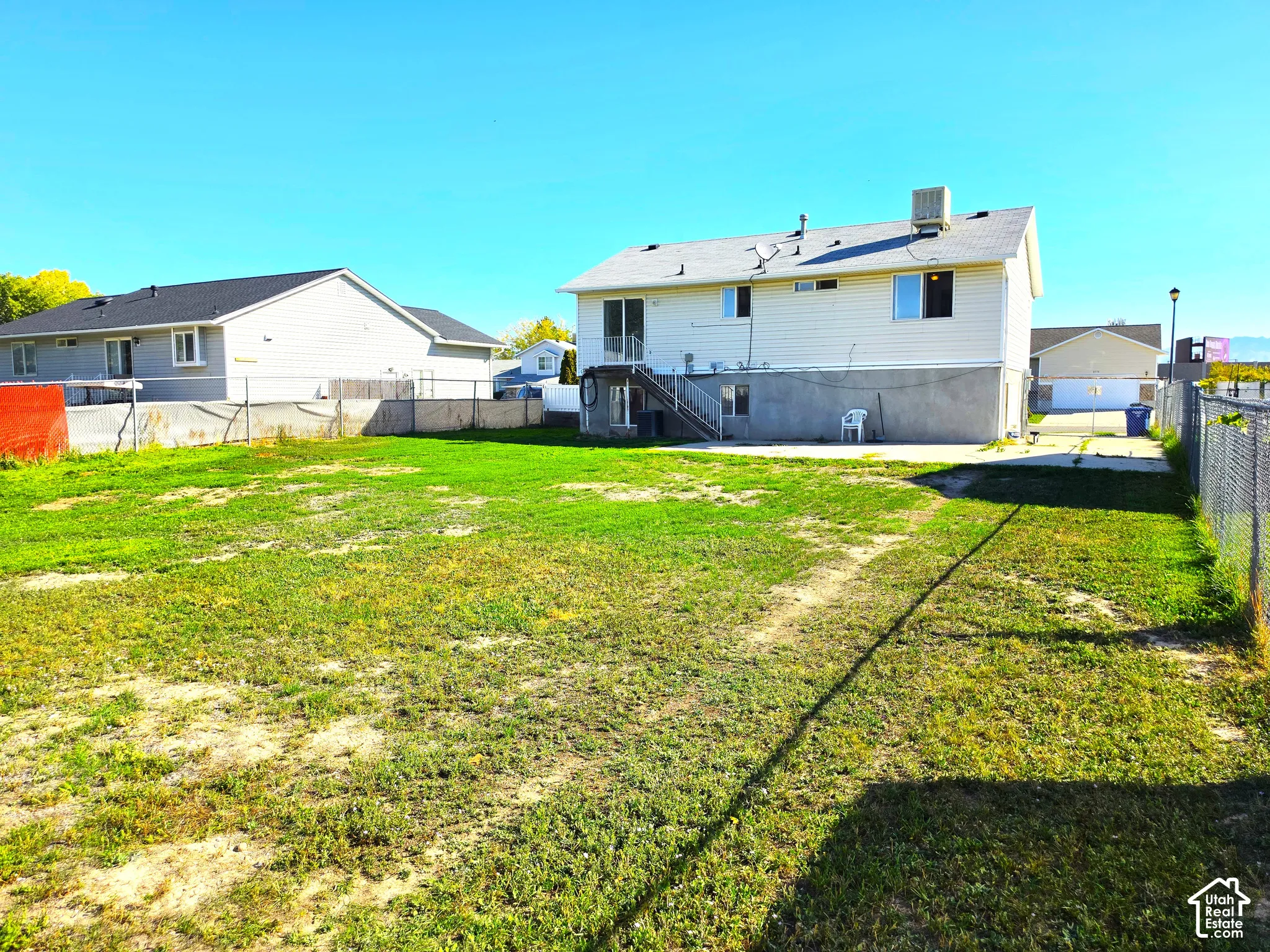Expansive grassy yard area with chain-link fencing