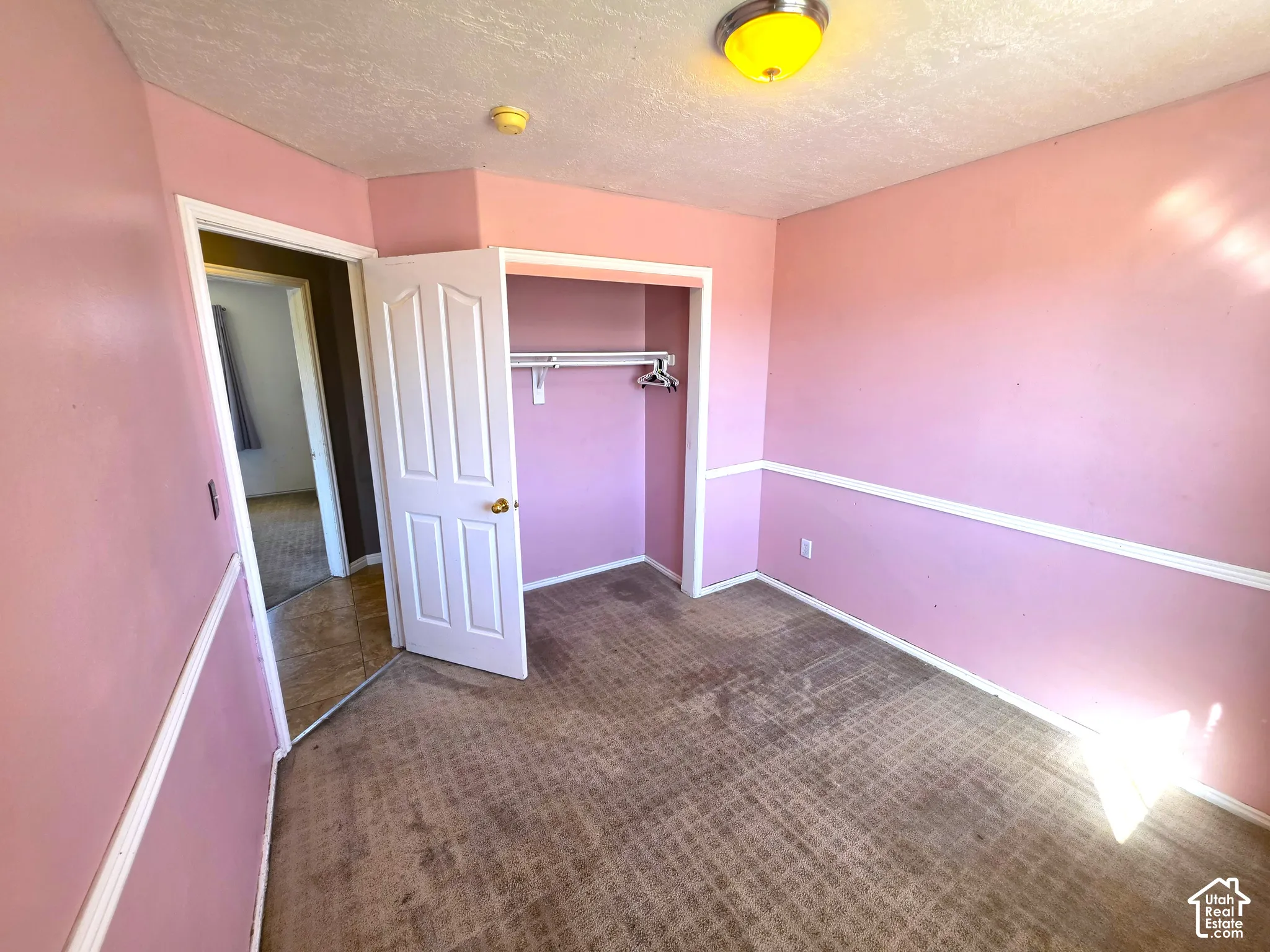 Recessed closet with clothes rod, paneled interior door, and overhead flush-mount lighting
