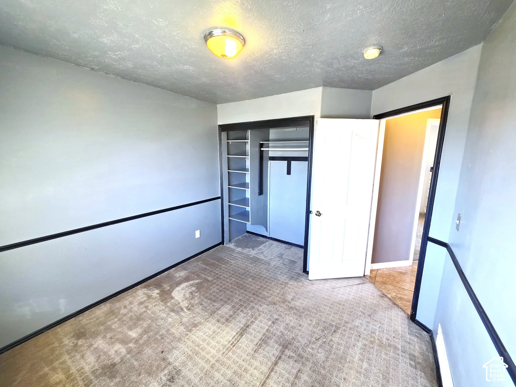 Built-in closet shelving, wall-mounted light fixtures, and a neutral wall color palette