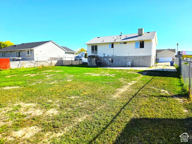 Expansive grassy yard area with chain-link fencing