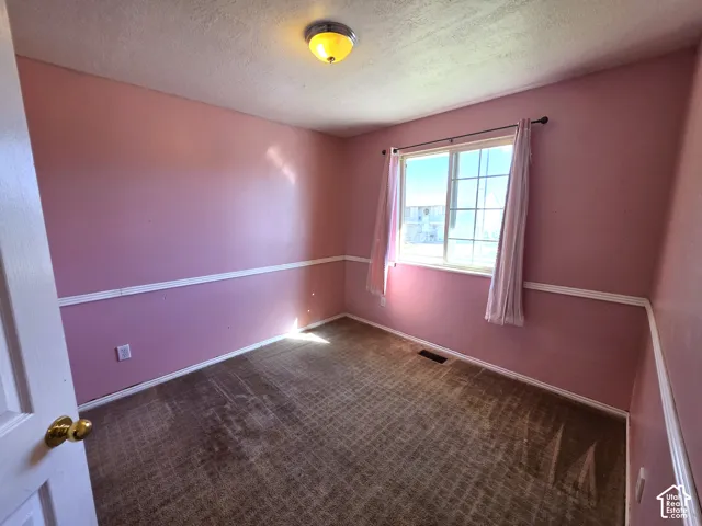 Wall-mounted light fixture, window with grid pattern, carpeted flooring, and white trim