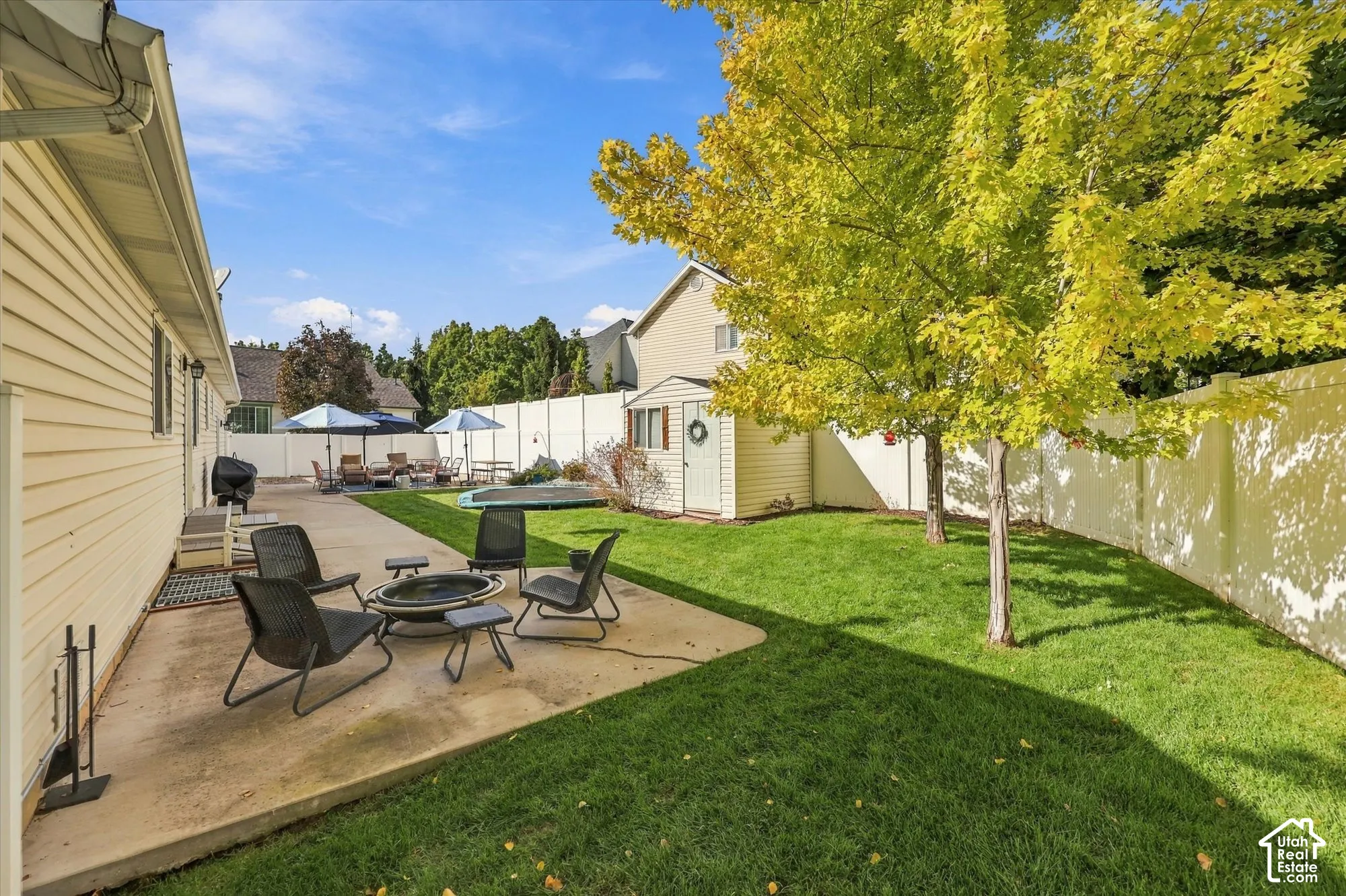 Expansive backyard with a concrete patio, green lawn, and privacy fencing
