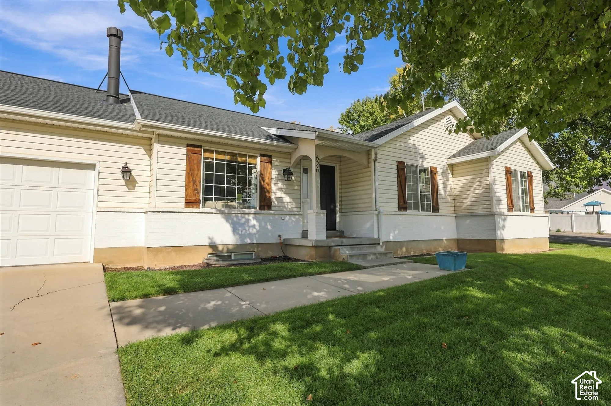 Exterior featuring light-toned siding, dark roof shingles, and an attached single-car garage
