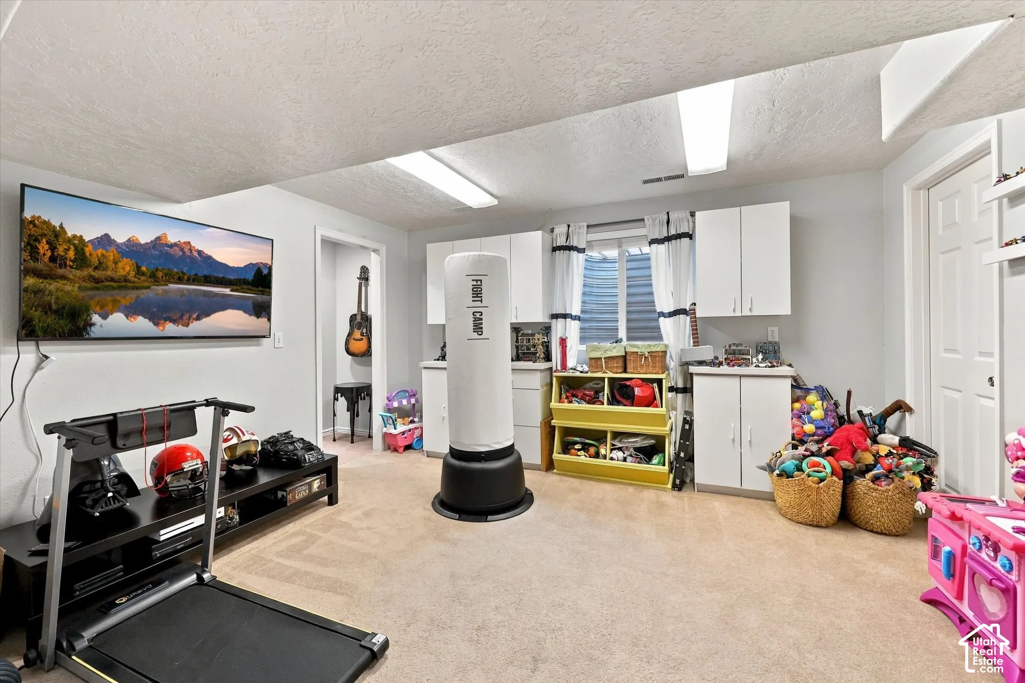 Recessed window with white blinds, neutral carpeting, white wall-mounted cabinetry, and a white interior door