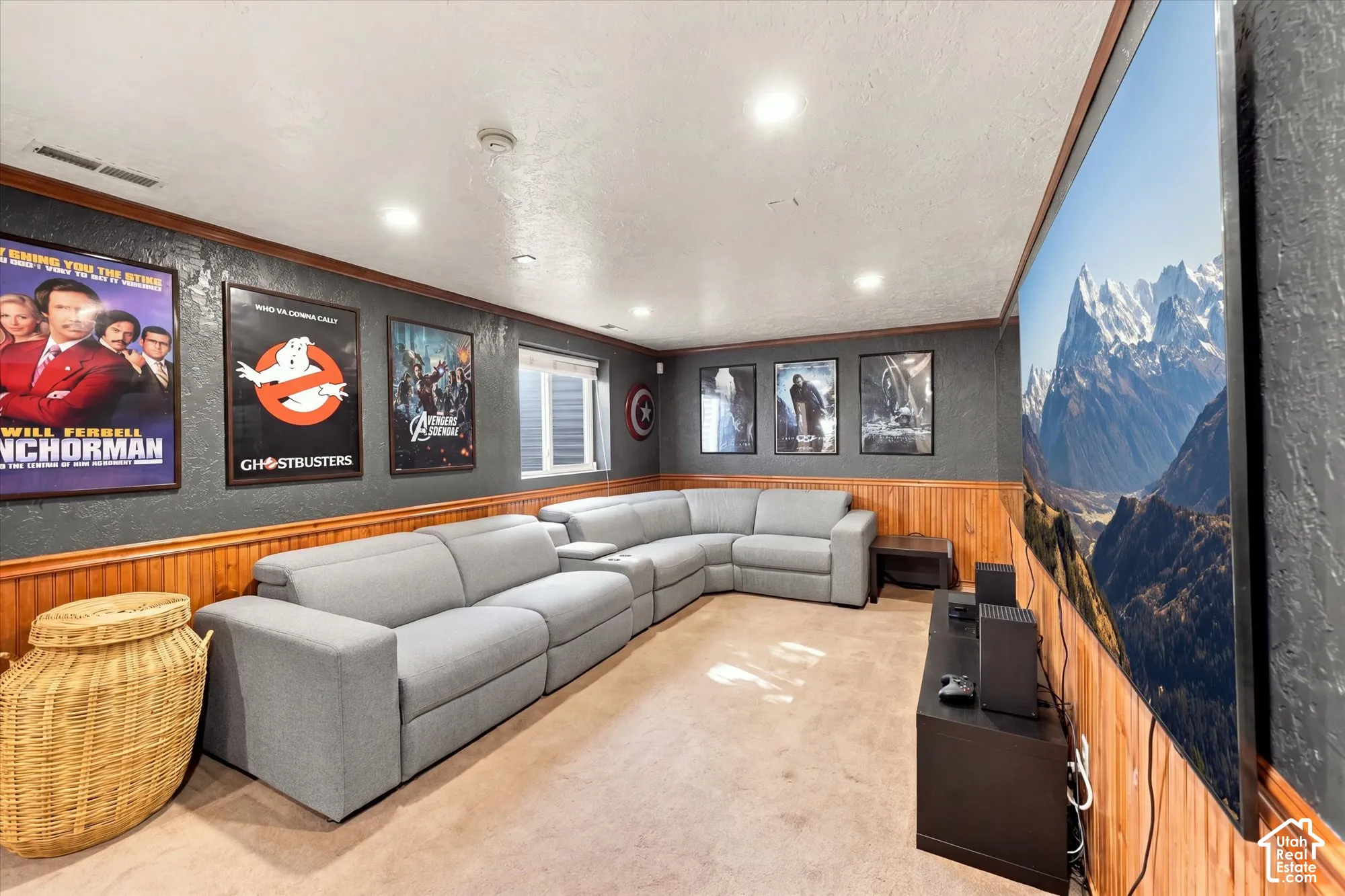 Lower level entertainment area featuring wood paneling, recessed lighting, and a window with blinds