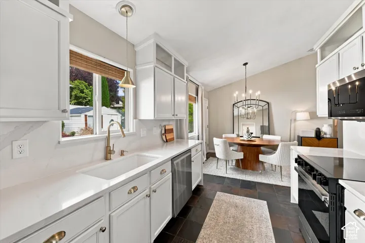 White shaker cabinetry with gold-tone hardware, stainless steel appliances, and a white integrated sink with a gooseneck faucet