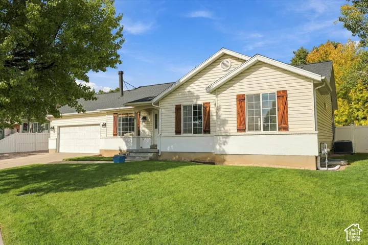 Single-story residence featuring light-colored siding, a dark roof, and decorative window shutters