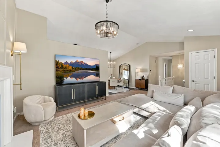 Vaulted ceiling, recessed lighting, chandelier, fireplace with mantel, built-in media console