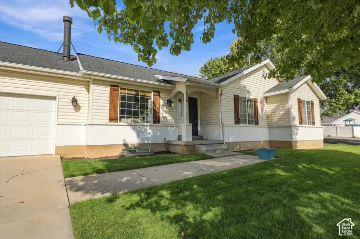 Exterior featuring light-toned siding, dark roof shingles, and an attached single-car garage