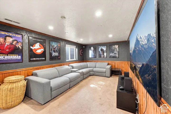 Lower level entertainment area featuring wood paneling, recessed lighting, and a window with blinds