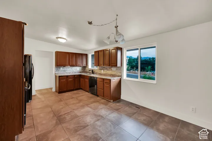 Kitchen featuring wood cabinetry, stone countertops, and a tile backsplash