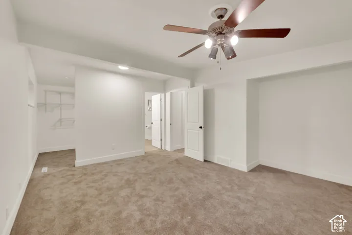 Wall-to-wall carpeting, white walls, built-in shelving, ceiling fan with lighting, and recessed lighting