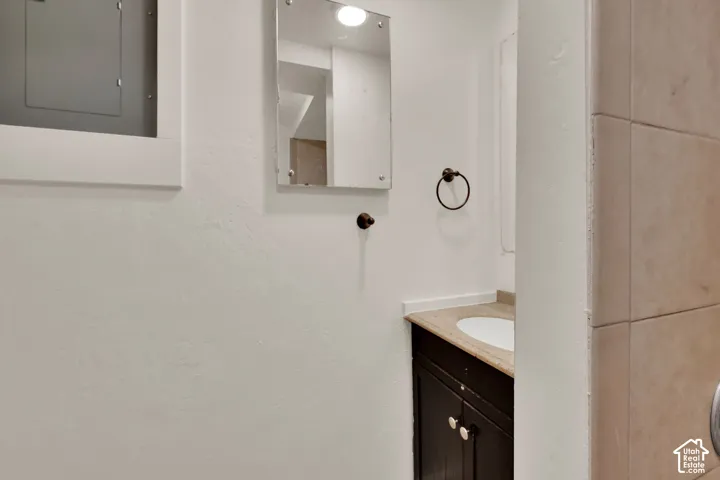 Vanity with a built-in sink, light-toned countertop, and dark wood-finish cabinetry