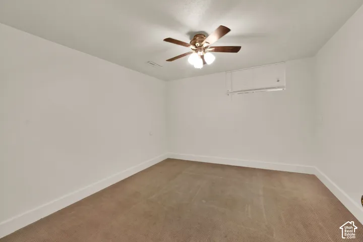 Ceiling fan with integrated lighting, textured carpeting, white wall paint, and white trim