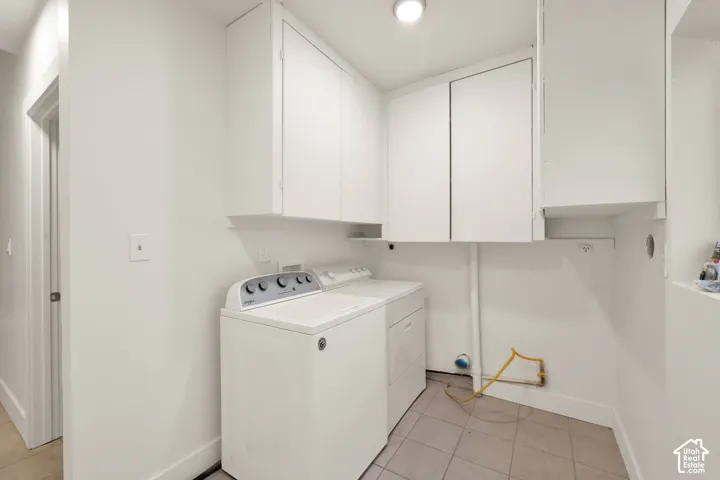 Laundry area featuring wall-mounted cabinetry and tiled flooring