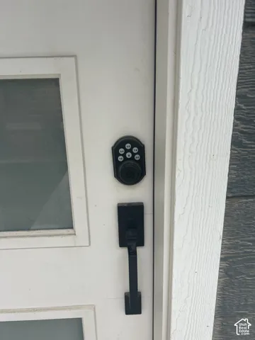White entry door with inset glass panels, black electronic keyless entry system, and black handle set