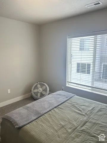 Carpeted flooring, window with blinds, and white baseboards