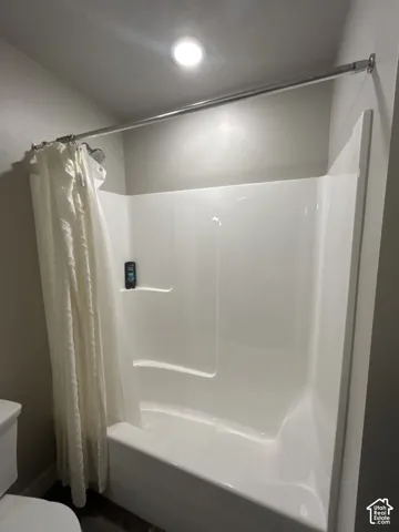 White acrylic tub and shower combination with built-in shelving