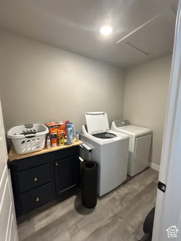 Laundry area featuring wood-finish flooring, built-in cabinetry with a wood countertop, and recessed ceiling lighting