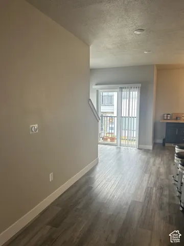 Wood-finish flooring, recessed lighting, white baseboards, sliding glass door, and a built-in breakfast bar