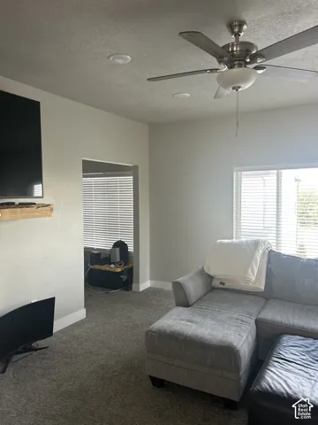 Recessed ceiling lights, ceiling fan with integrated lighting, and a door frame leading to an additional space