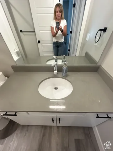 White vanity with integrated sink, chrome faucet, and gray countertop