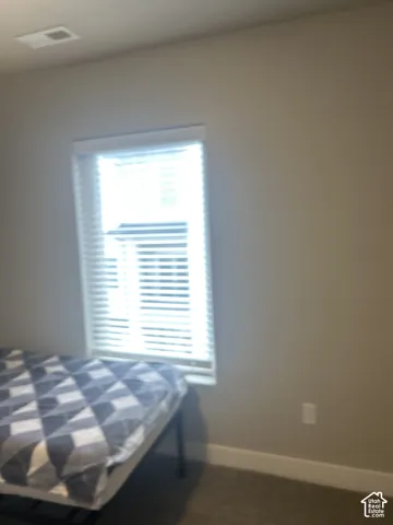 Window with white horizontal blinds, light-colored walls, and carpeting