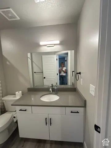 White vanity with matte black hardware, integrated sink, and stone-finish countertop