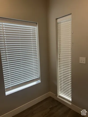 Wood-finish flooring with white trim and neutral wall paint