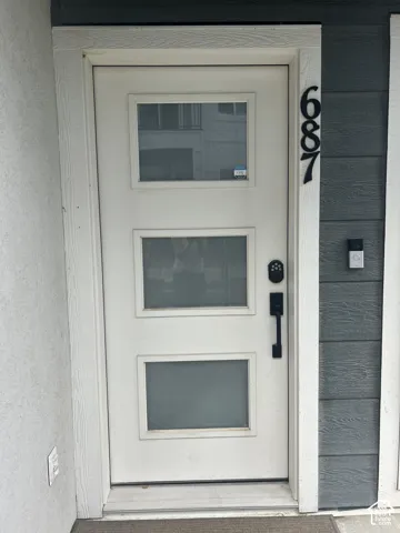 White entry door with three rectangular lites and black hardware