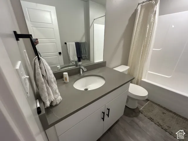 White vanity with matte black hardware, a grey countertop, and an undermount sink