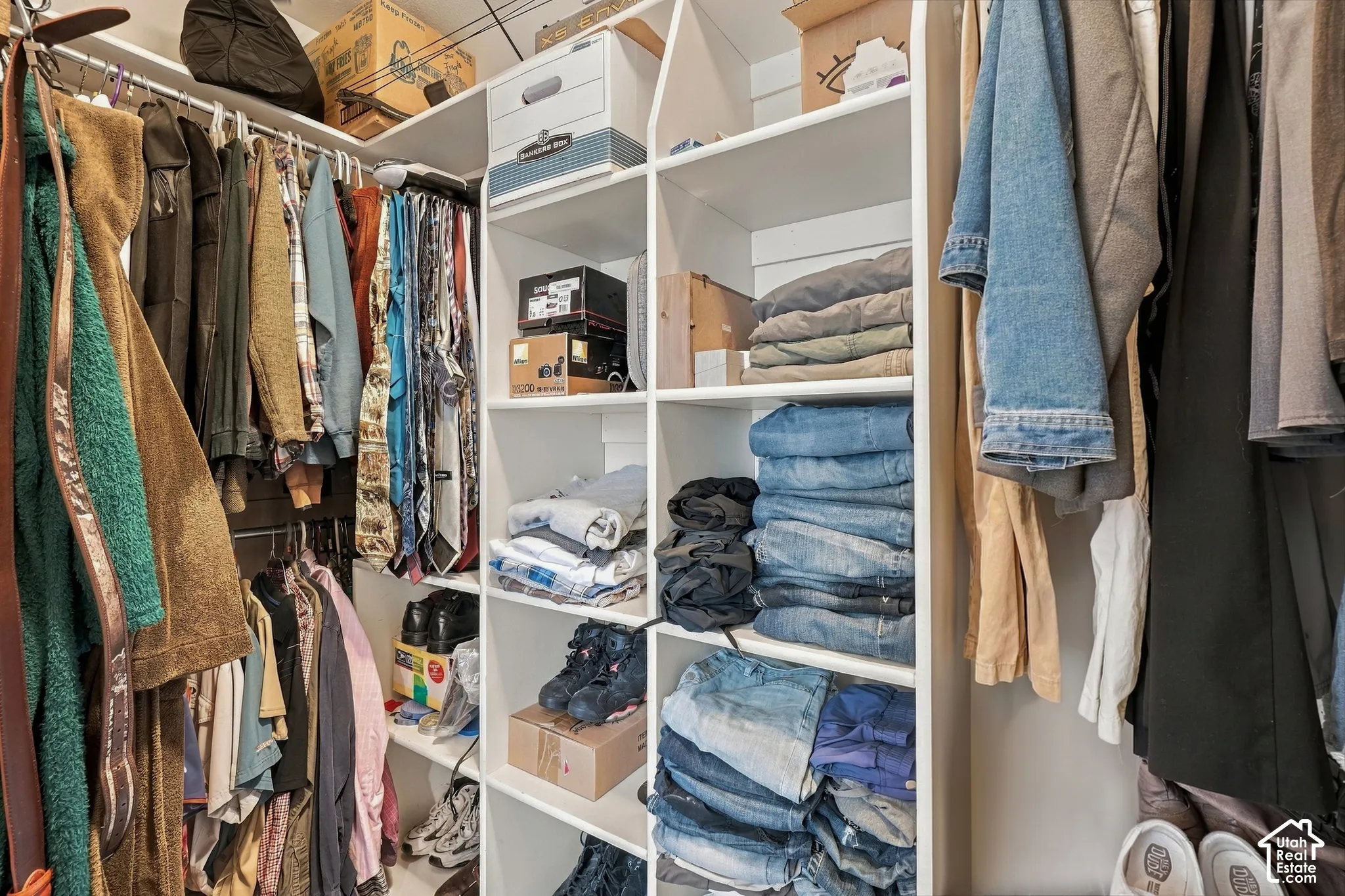 Custom closet system featuring white shelving and multiple hanging rods