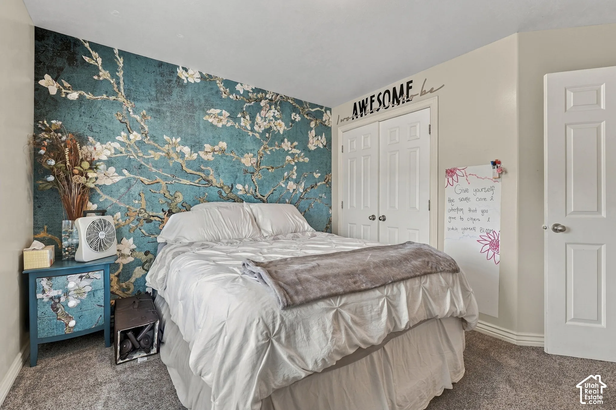 Textured accent wall, neutral wall paint, paneled doors, carpeted flooring