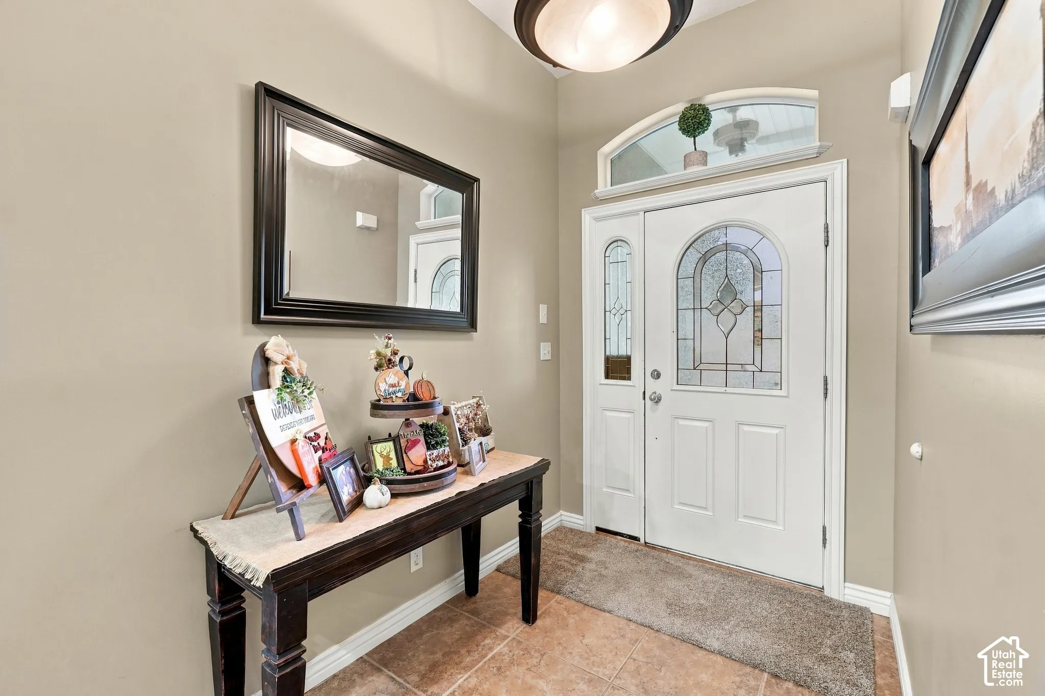 Entryway featuring a white door with a decorative glass insert, a sidelight, and an arched transom window