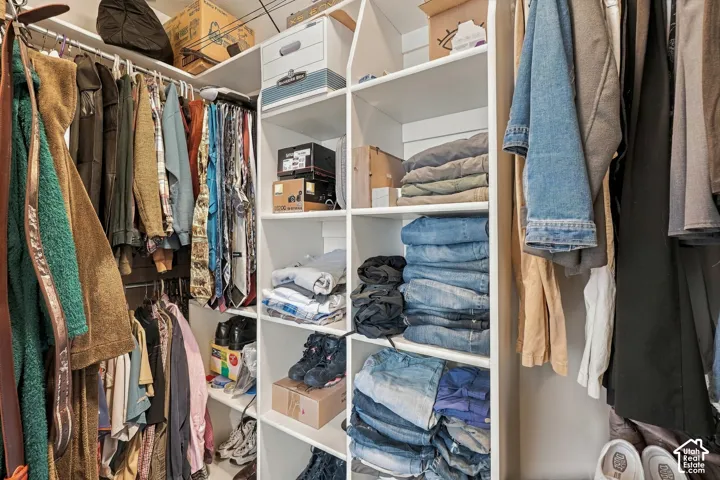 Custom closet system featuring white shelving and multiple hanging rods