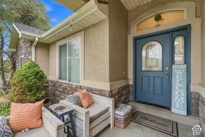 Entryway featuring a blue paneled door with an arched glass insert, sidelight, and transom window