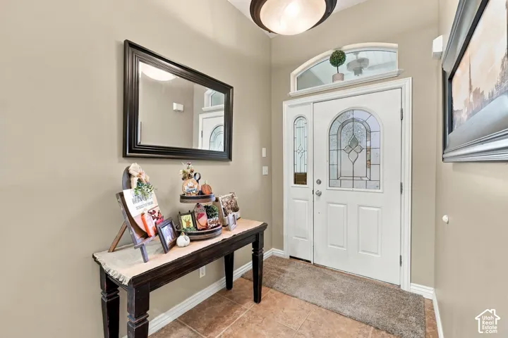 Entryway featuring a white door with a decorative glass insert, a sidelight, and an arched transom window