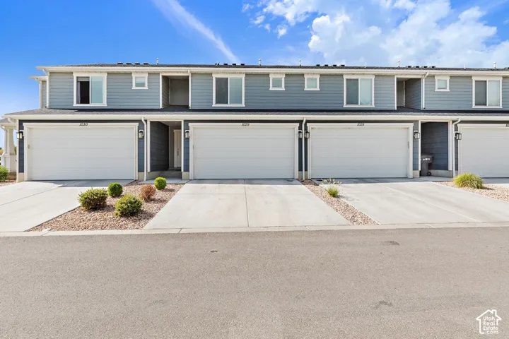 Contemporary exterior with blue siding, multiple windows, and individual garage doors