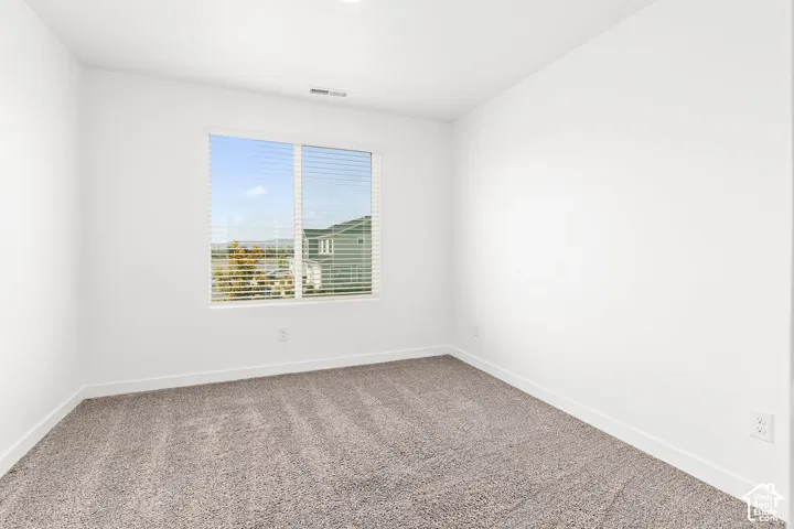 Neutral wall finishes, recessed lighting, window with horizontal blinds, and carpeting