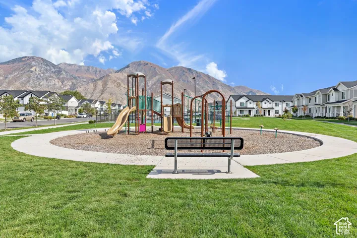 Community playground with a multi-level play structure, slide, and bench seating