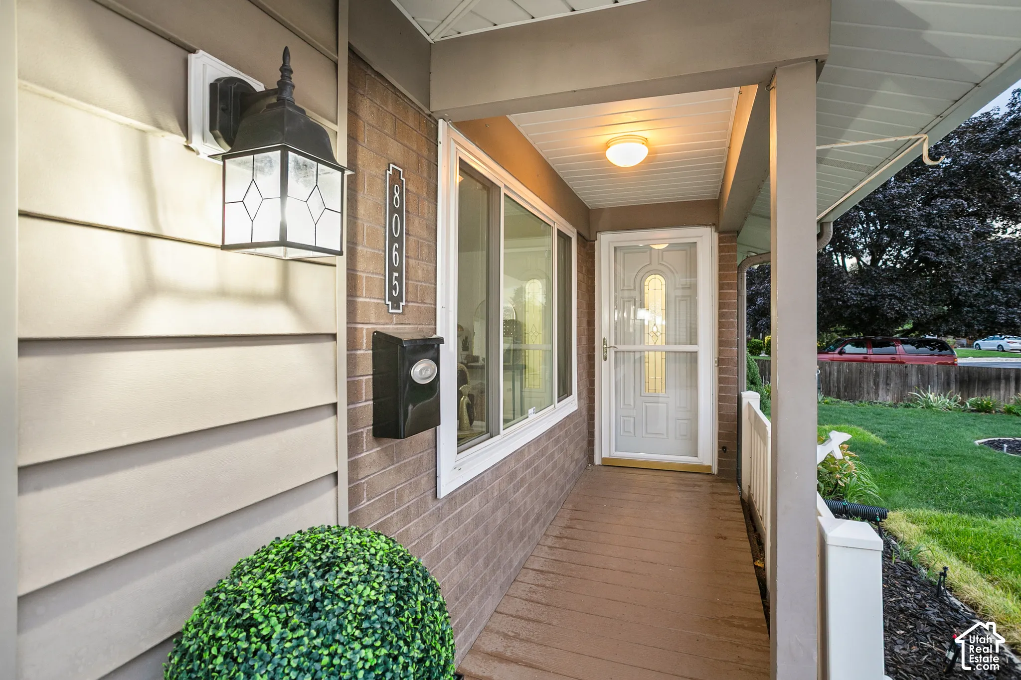 Covered porch entry featuring wood-finish flooring