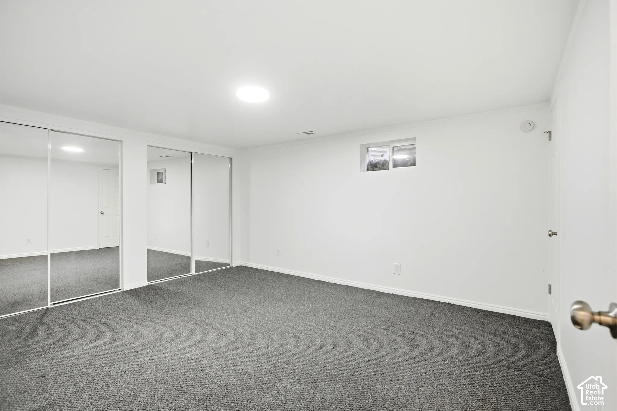Recessed lighting illuminating a spacious room with wall-to-wall carpeting
