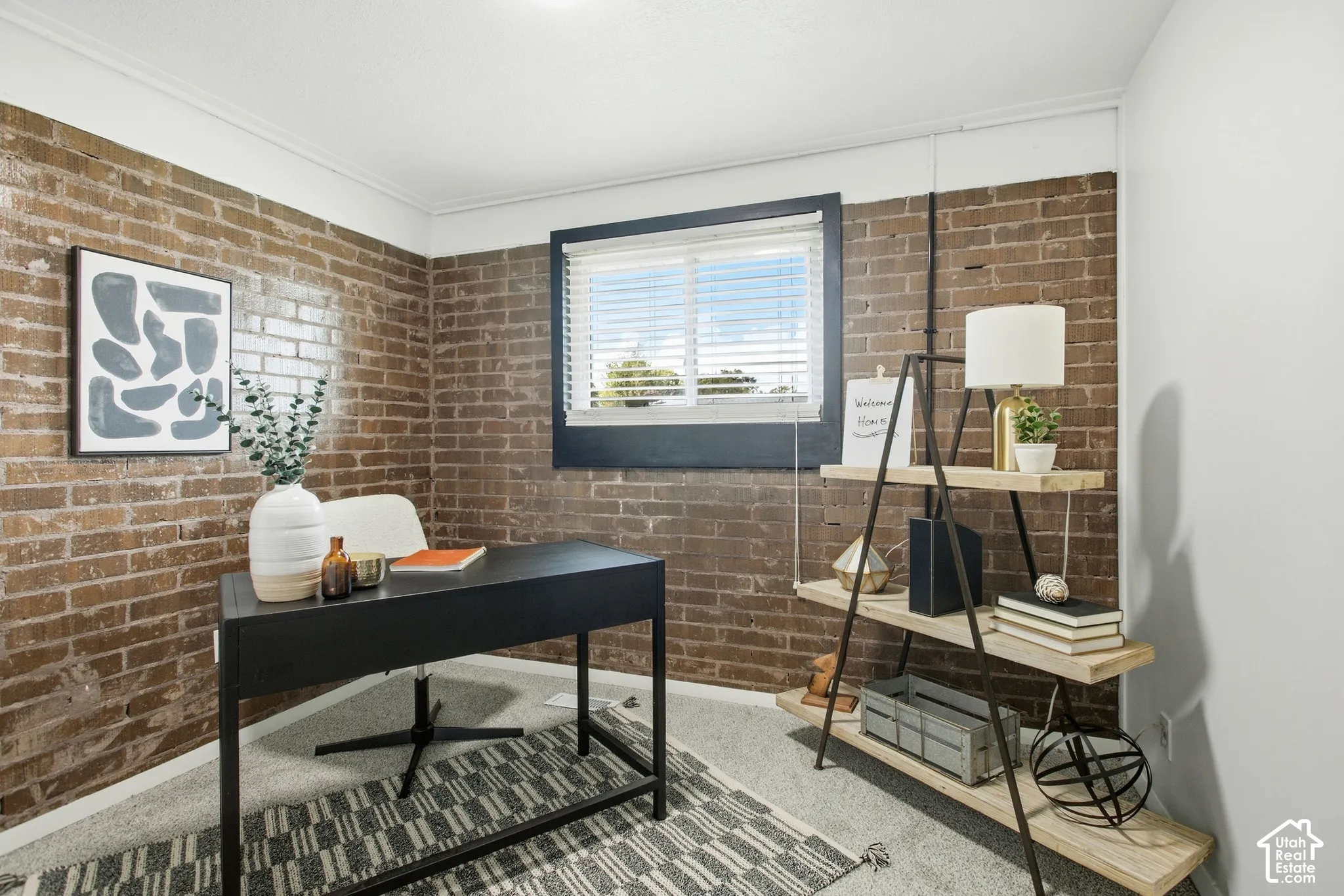 Exposed brick wall accents, window with blinds, recessed ceiling lighting, and a built-in shelving unit
