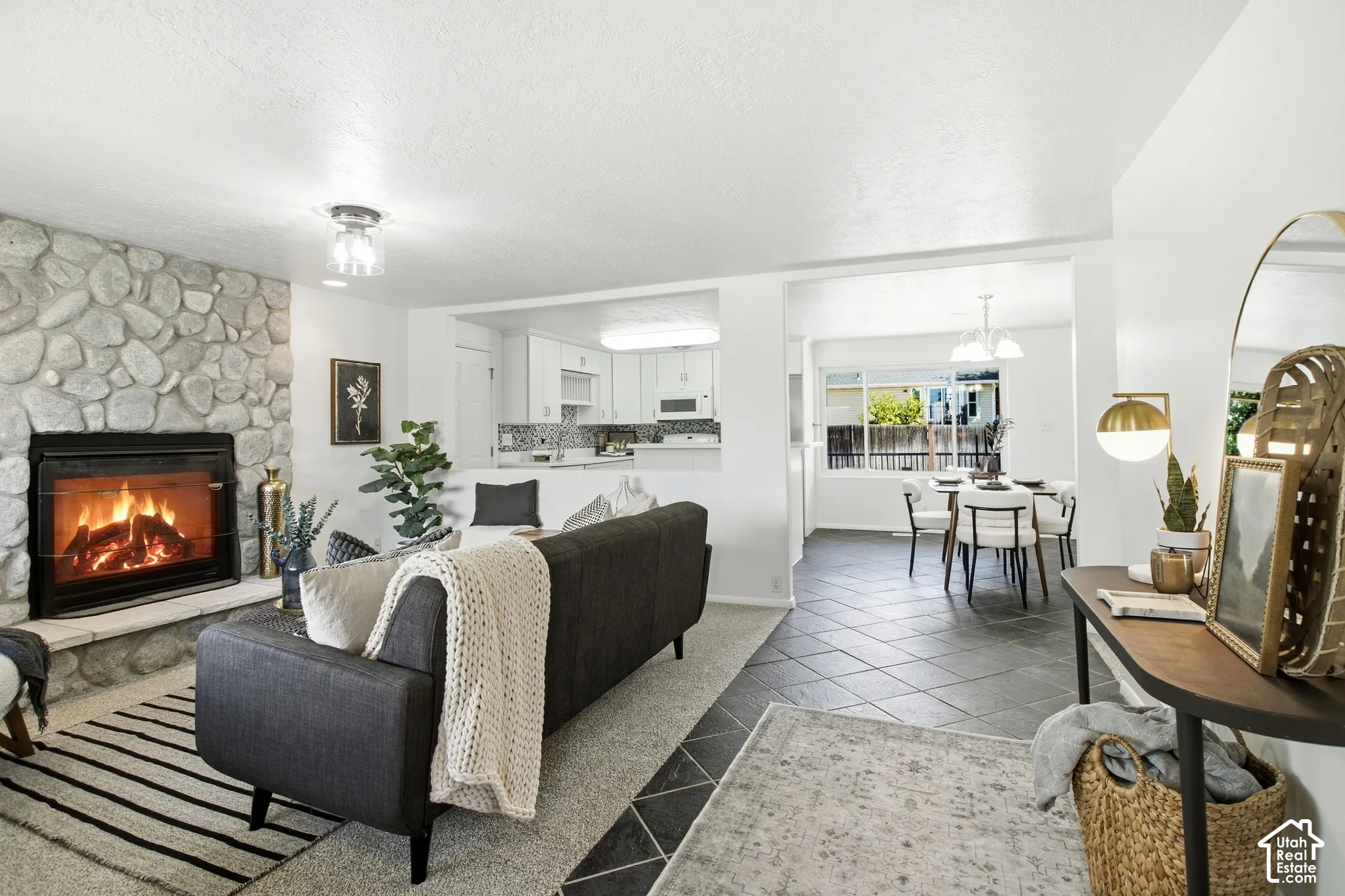 Stone-clad fireplace with hearth, recessed lighting, tile flooring, and integrated dining area