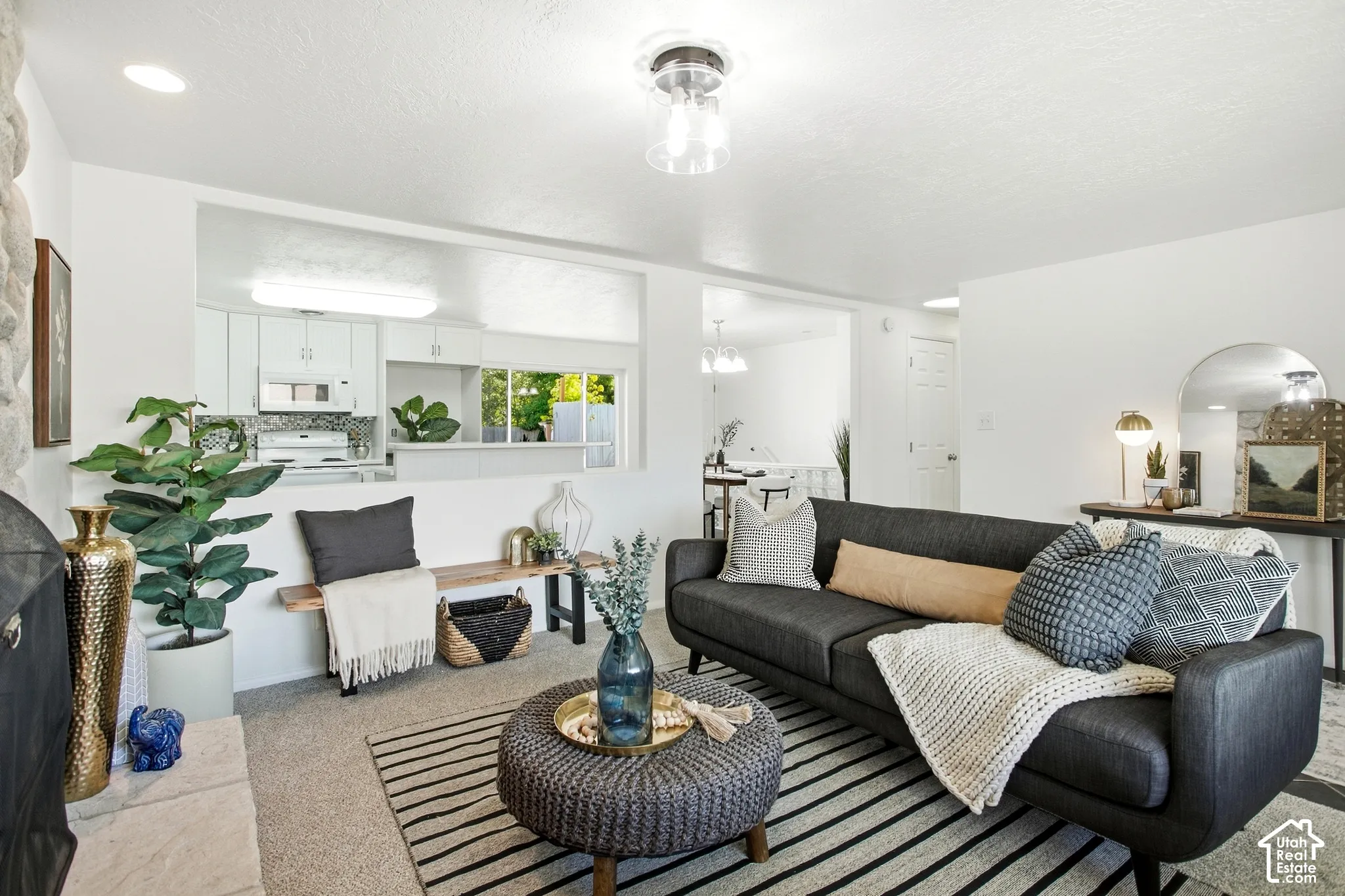 Carpeted living area with a stone fireplace surround and recessed lighting