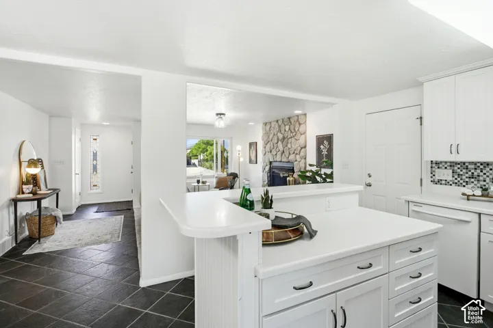 Kitchen island with white cabinetry and integrated breakfast bar