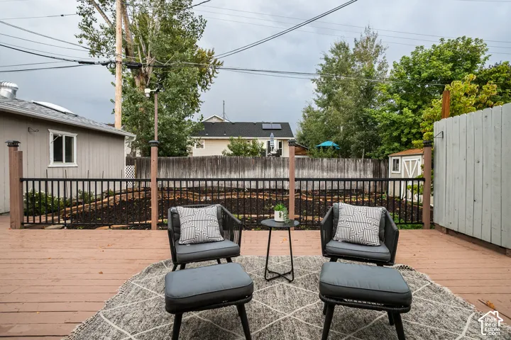 Wood deck with black metal railing and built-in privacy screen and east facing, peek a boo mountain views