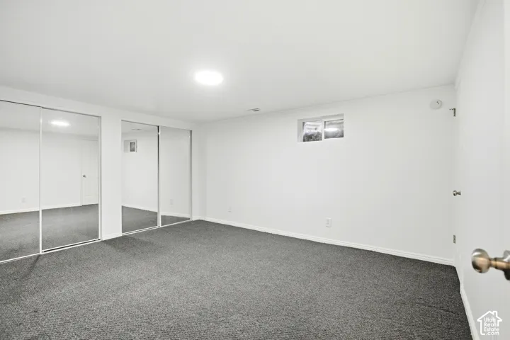 Recessed lighting illuminating a spacious room with wall-to-wall carpeting